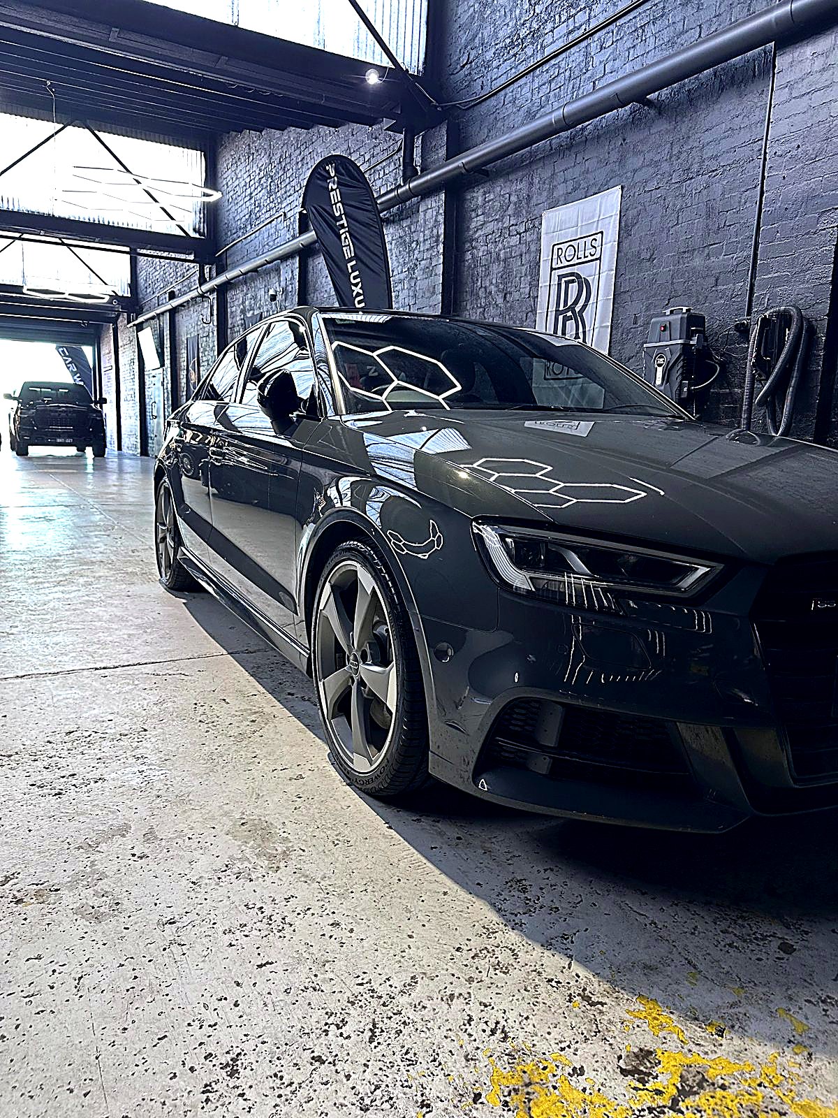After — the same Audi S3, gloss-black and spotless under studio lighting